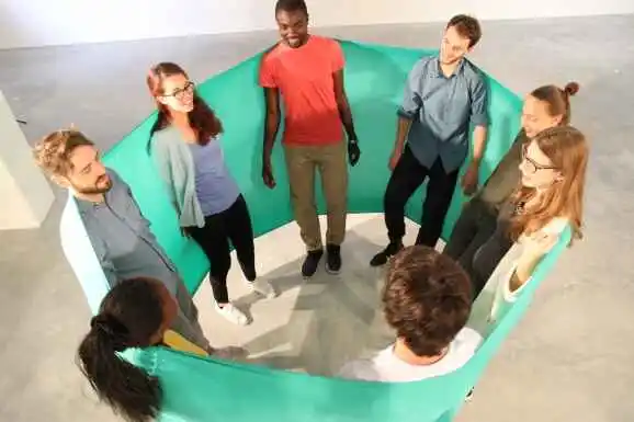 Un exercice en groupe à l'intérieur d'un très grand ruban vert