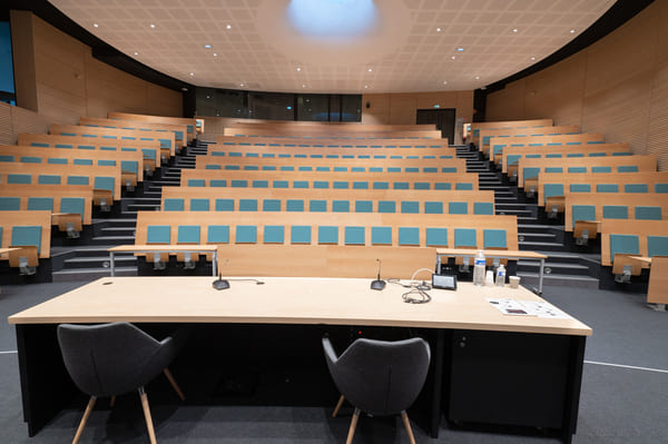 Un amphithéâtre d'université, vide. Vue de la place de l'orateur.