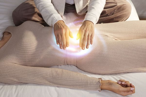 Une thérapeute de healing touch  et son patient sur une table de massage